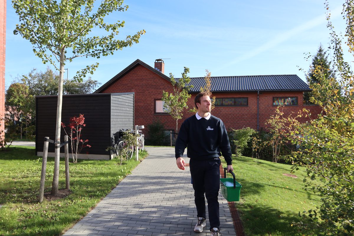 Vinduespudser fra Glans Polering på vej op ad indkørslen til en kunde med spand og udstyr